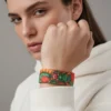 Beyaz kapüşonlu sweatshirt ile kombinlenmiş, yeşil ejderha desenli elastik kadın bileklik.