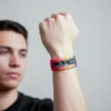 FENRIS KURT DESEN ELASTİK BİLEKLİK Fenris elastik bileklik – renkli arka plan üzerinde kurt illüstrasyonlu unisex kumaş bileklik, model üzerinde görünüm