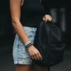 Siyah atlet ve şort giyen kadının bileğinde ikili Akrep burcu (Scorpio) elastik bileklik kombini.