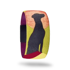 Köpek desenli bileklik. Turuncu gün batımı ve yeşil çim zemin üzerinde oturan siyah köpek silüeti desenli elastik bileklik.